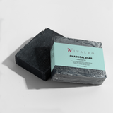 Ivalro Charcoal Soap: black bar resting on its wrapper